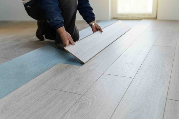 Worker carpenter doing laminate floor work Worker carpenter doing laminate floor work